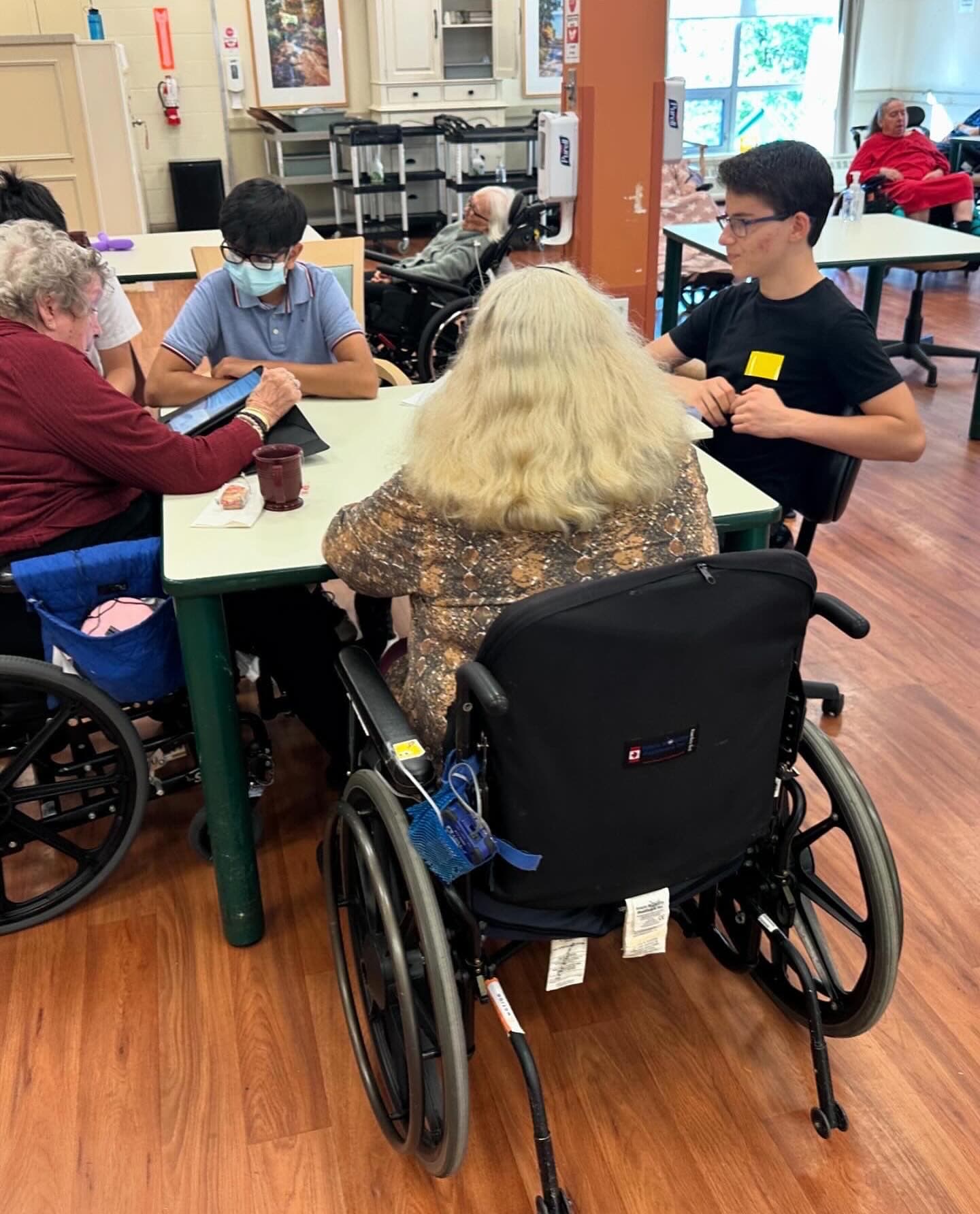 Volunteers helping seniors use tablets at Mackenzie Place